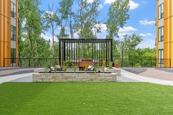 A black metal structure sits in the middle of a grassy area.